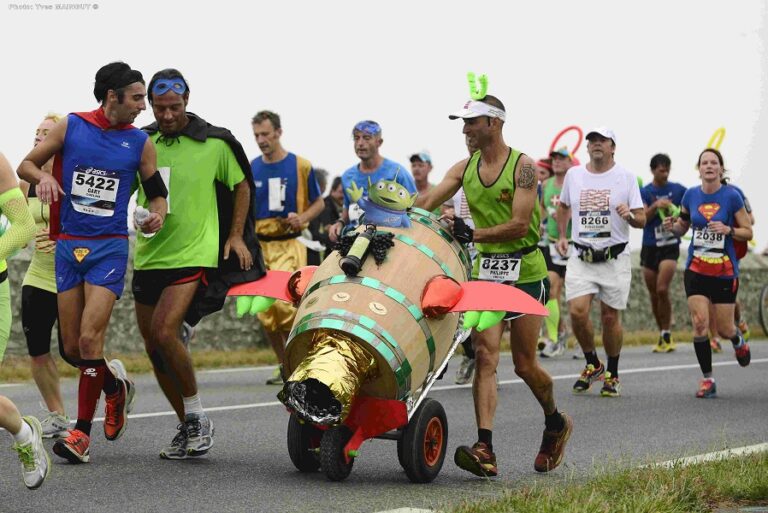 A runner pushing a barrel during the Marathon du Medoc 2024