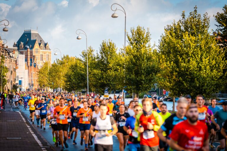 Photo of runners passing along the tree-lined routes of the Amsterdam Marathon 2024