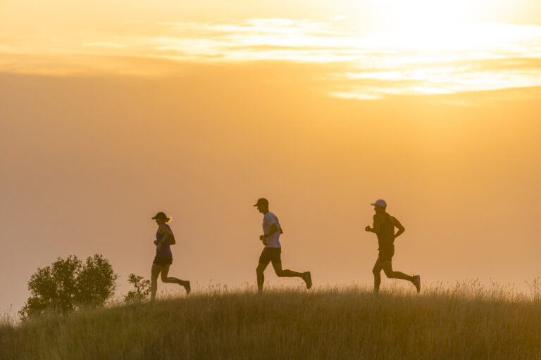 Runners passing the sunrise at the First Light Marathon 2024