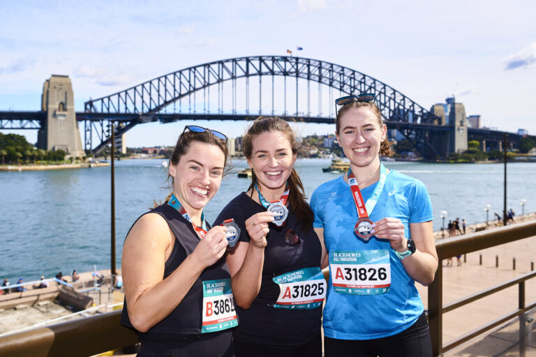 Runners pose with medals after completing the Sydney Marathon 2024