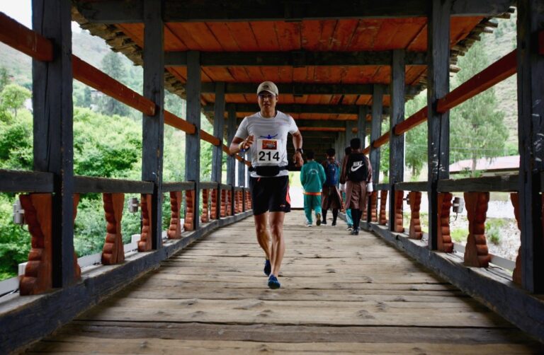 A runner crosses a bridge during the Bhutan Thunder Dragon Marathon