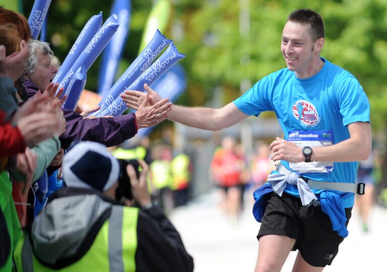 Photo of a runner interacting with crowds at the Edinburgh Marathon 2024