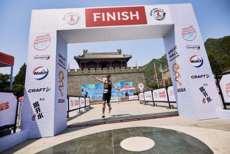 A runner crosses the finish line during the Great Wall Marathon 2025