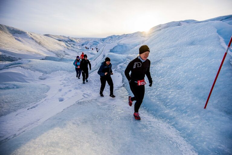 Runners passing over snowy terrain during the Polar Circle Marathon 2024