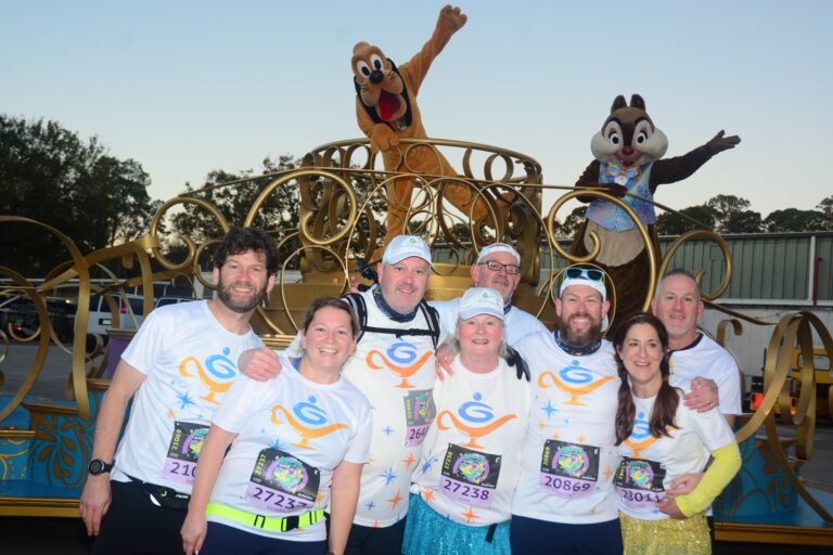 Runners pose with mascots before completing the Disney Marathon