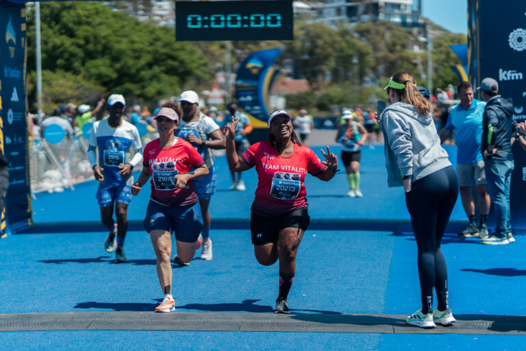 A runner celebrates as she crosses the finish line during the Cape Town Marathon