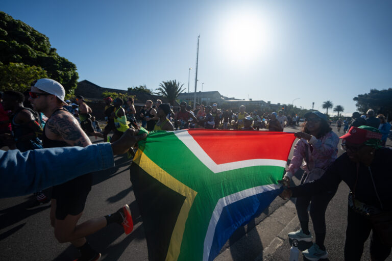 Spectators proudly hold a South African flag aloft during the Cape Town Marathon