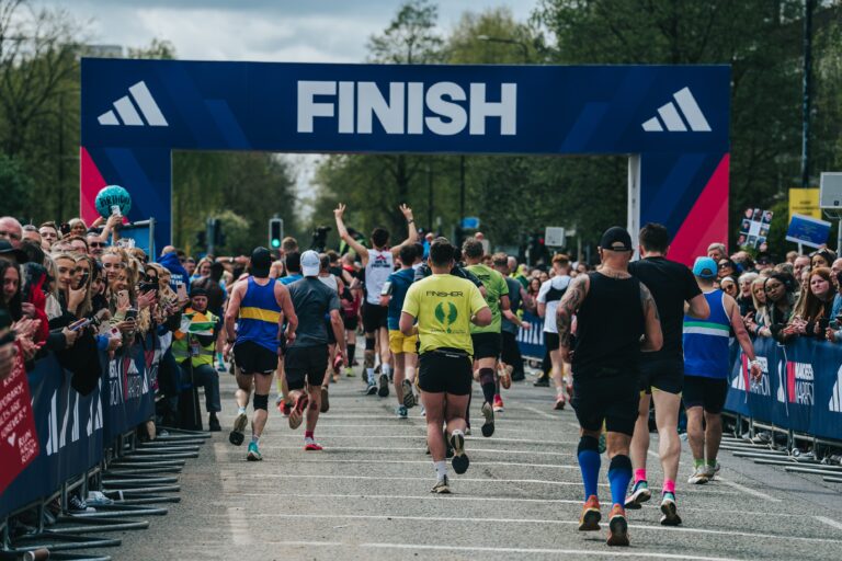 Runners crossing the finish line during the Manchester Marathon 2025