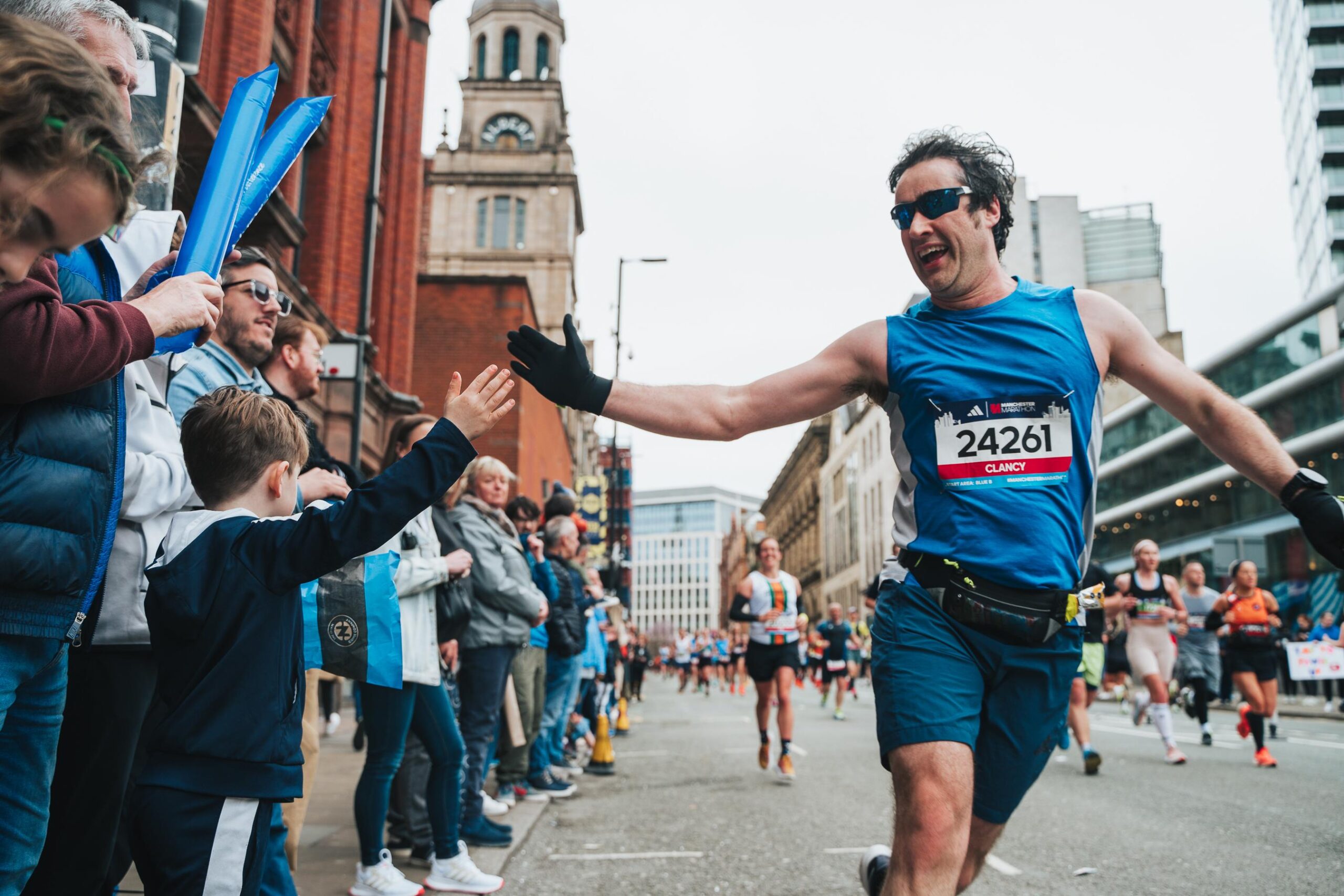 A runner interacting with supporters during the Manchester Marathon 2024