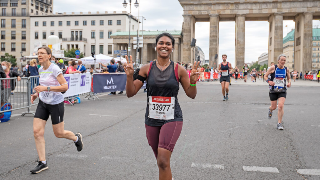 A young runner poses to camera as they cross the finish line during the Berlin Half Marathon, a half marathon part of the SuperHalfs series