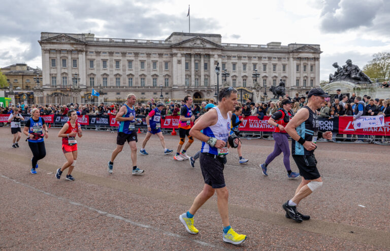 Runners passing Buckingham Palace as they approach the end of the 2025 London Marathon course