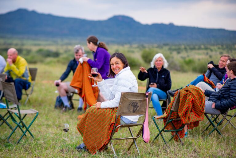Guests enjoying a glass of wine amidst the nature of the Amazing Maasai Marathon