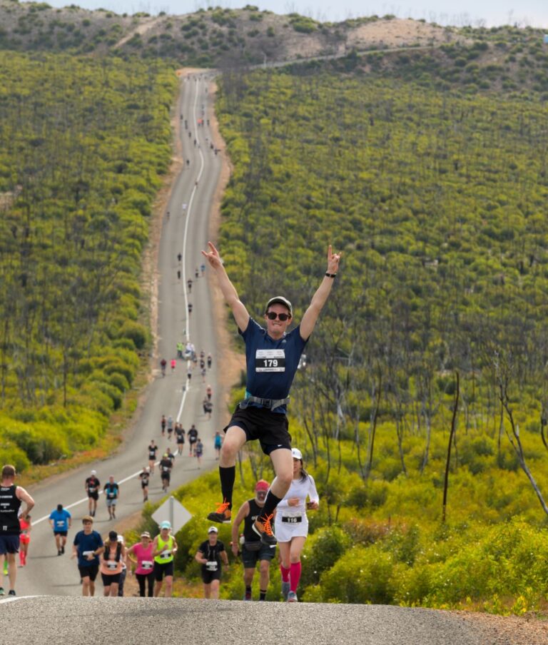 A runner jumps in front of a stunning view during the Kangaroo Island Marathon