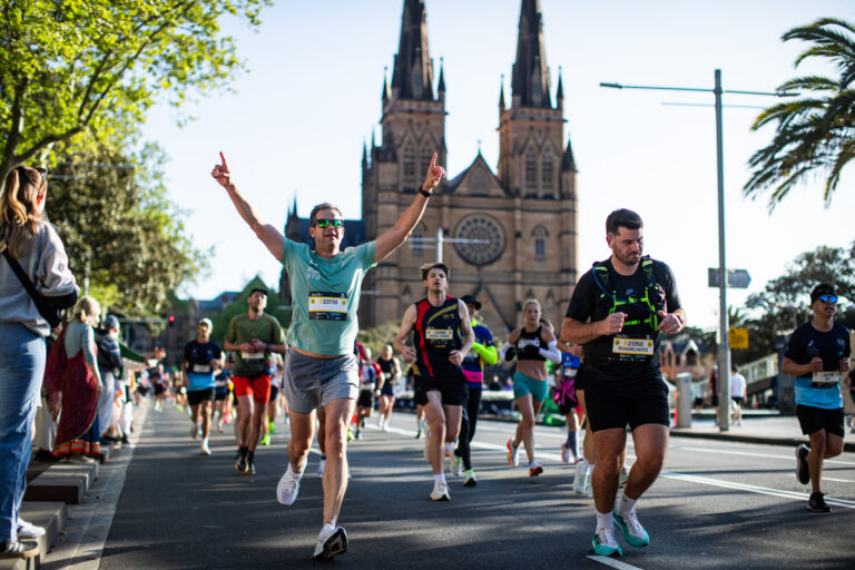 The two different moods of a marathon! A runner celebrates as another one pushes through during the Sydney Australia Marathon