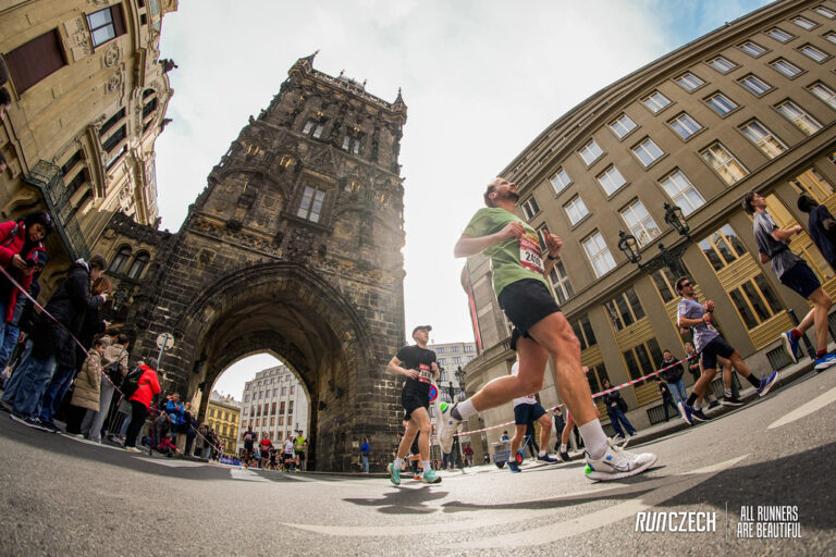 A runner passes under an historic monument during the Prague Half Marathon