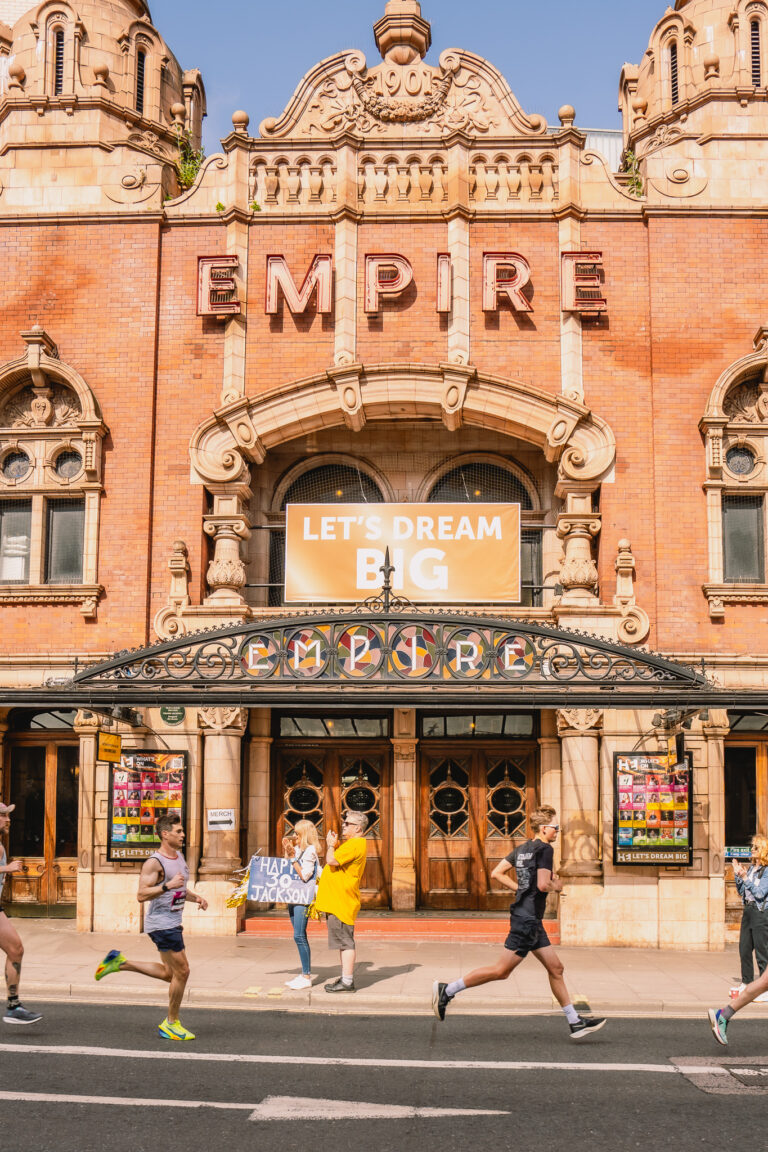 Runners pass the famous Hackney Empire during the Hackney Half Marathon