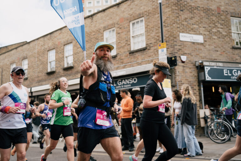A race pacer points to the camera during the Hackney Half Marathon