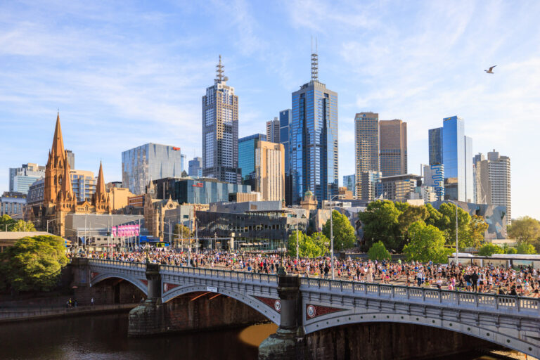 Runners crossing a bridge in front of the Melbourne skyline during the Melbourne Marathon
