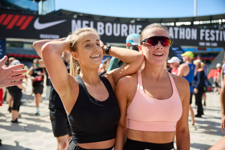 Two female runners celebrate having completed the Melbourne Marathon