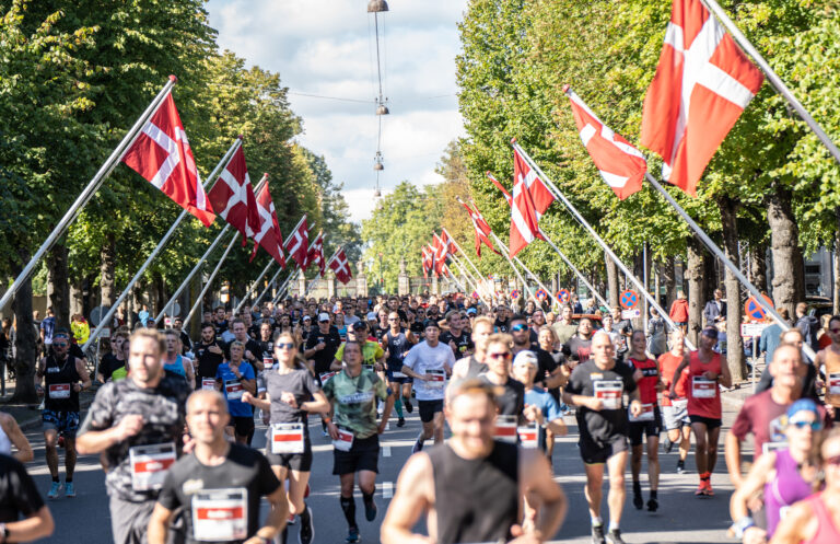 Opposite view of runners passing along the Danish flag lined street during the Copenhagen Half Marathon