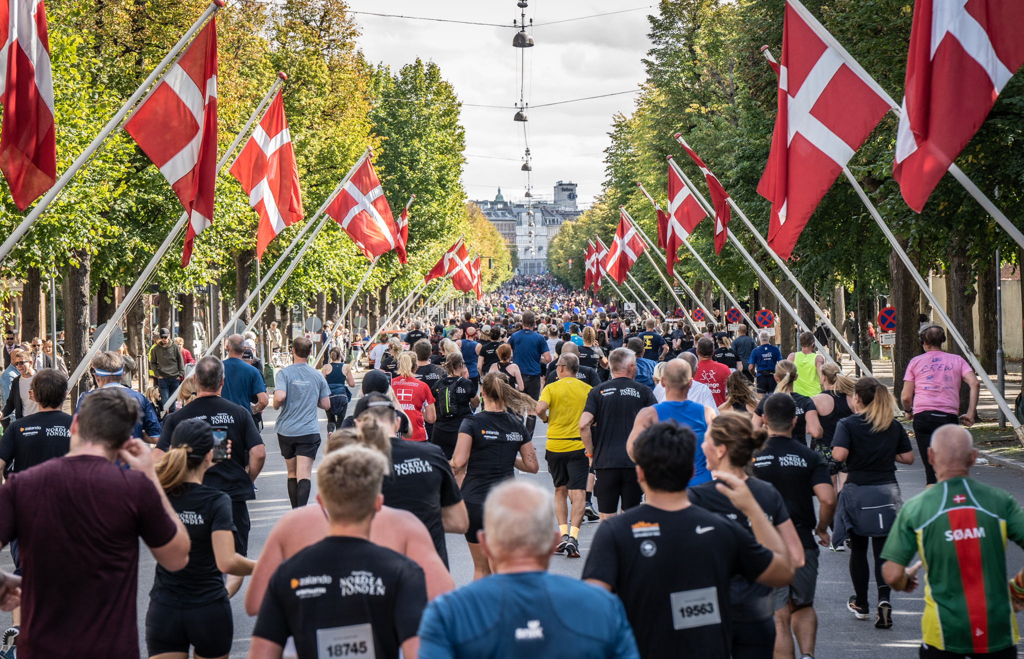 Runners passing along a street lined with Danish flags during the Copenhagen Half Marathon 2027