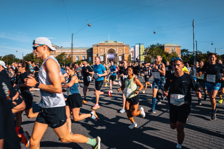 Runners passing in front of historic Copenhagen buildings during the Copenhagen Half Marathon