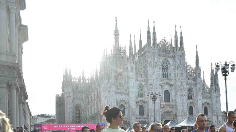 Runners preparing for the Milan Marathon in front of the Duomo di Milano
