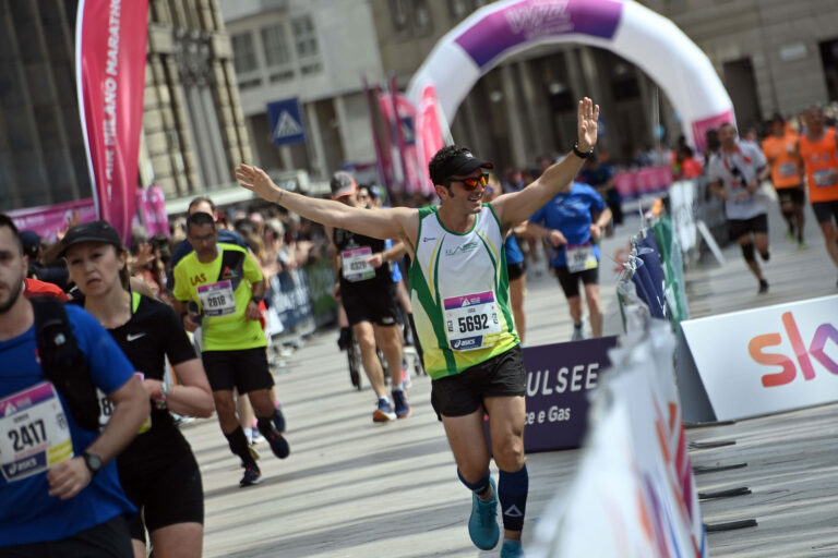 A runner celebrates as they head towards the end of the Milan Marathon