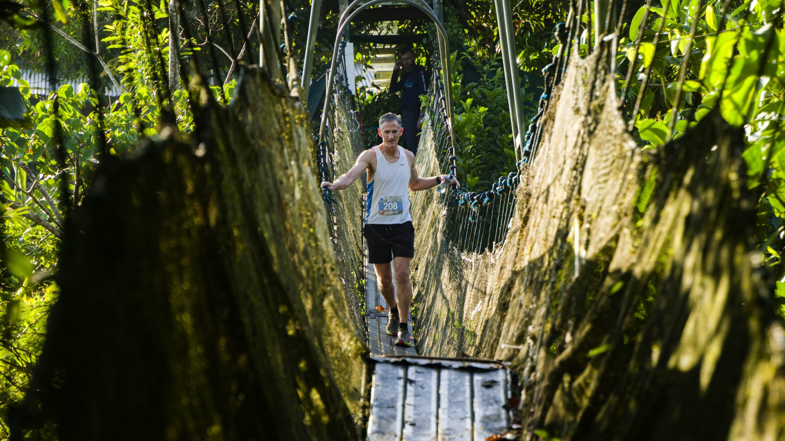 A male runner crosses a swing bridge during the Amazon Marathon 2026