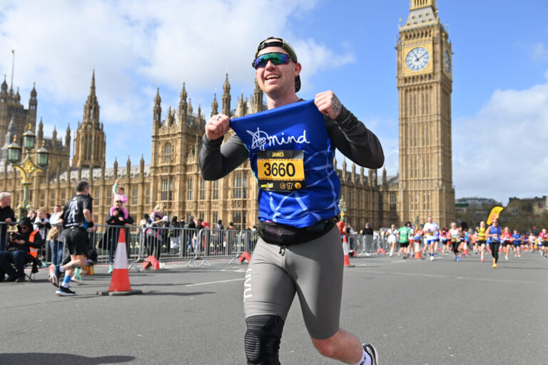 A runner poses his bib number to the camera during the London Landmarks Half Marathon 2025