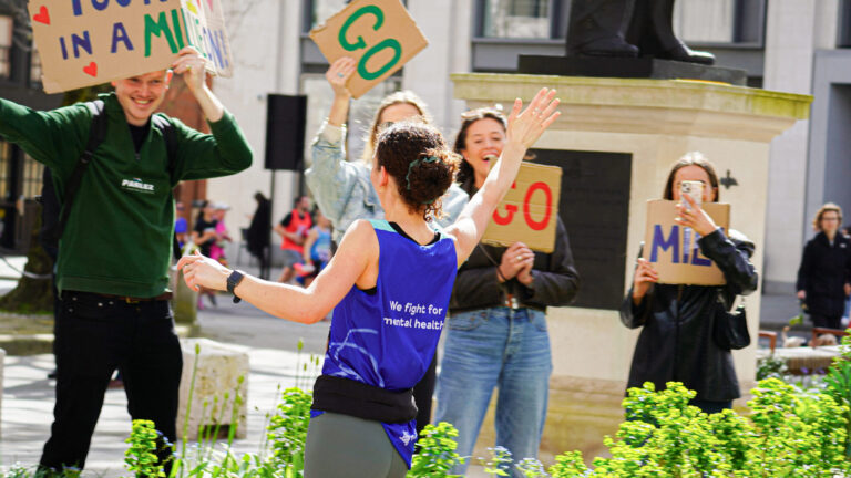 A runner high fives supporters during the London Landmarks Half Marathon 2025