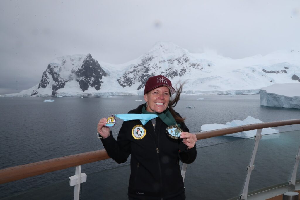 A runner poses with their Antarctica Marathon and Seven Continents Club medal