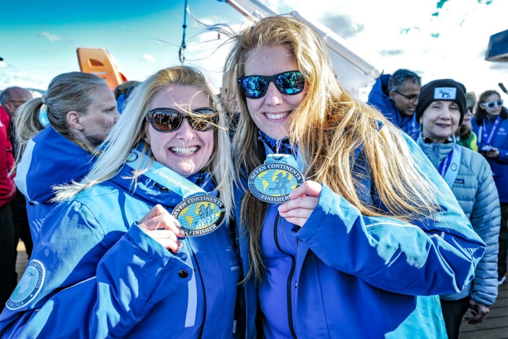 Runners pose in Antarctica with their Seven Continents Club medals