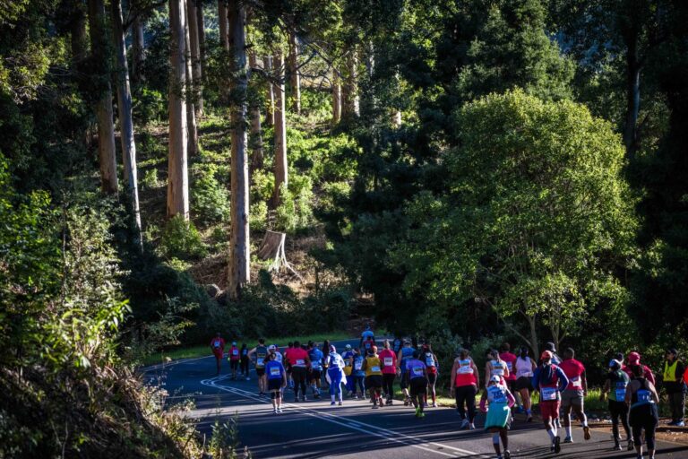 Runners passing through beautiful rural countryside during the Two Oceans Ultra Marathon