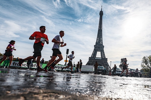 Runners taking part in the Paris Marathon passing the Eiffel Tower
