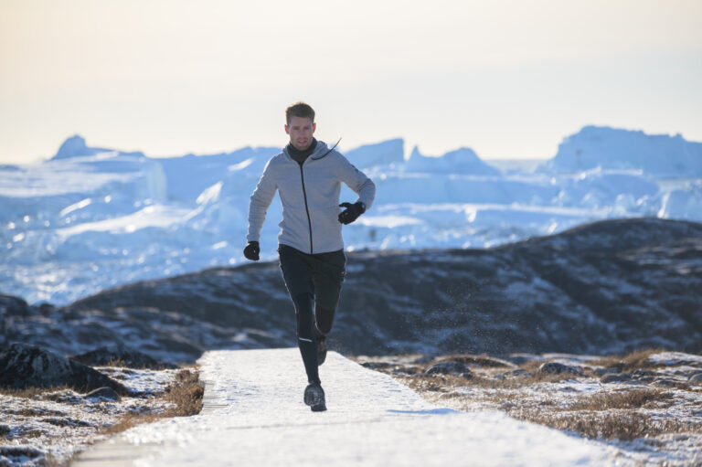 A photo of a runner taking part in the Icefjord Midnight Marathon demonstrating running during winter