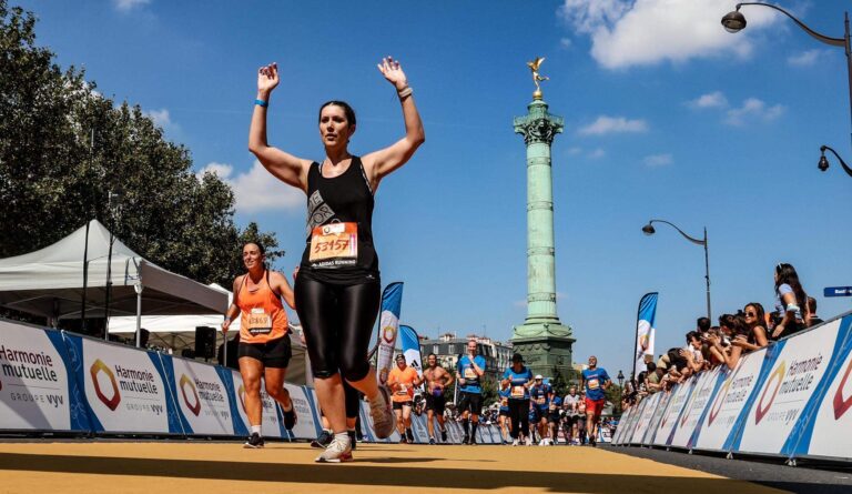 A runner celebrates having come to the end of the Paris Half Marathon